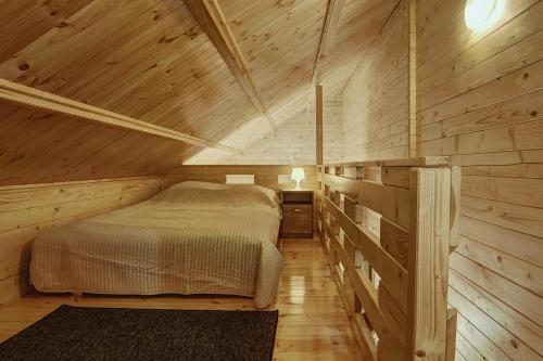 ウストロニエ・モルスキエにあるBiała Wioska 1の木造キャビン内のベッド1台が備わるベッドルーム1室を利用します。