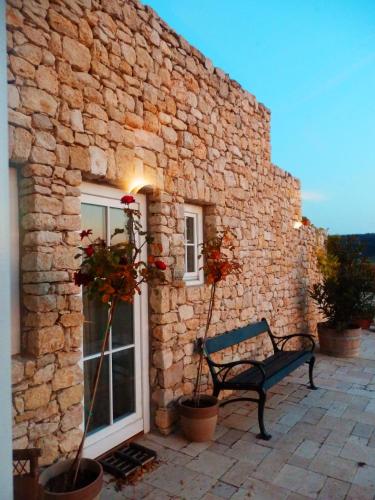 a bench sitting in front of a stone building at Liszkay Borkúria in Monoszló