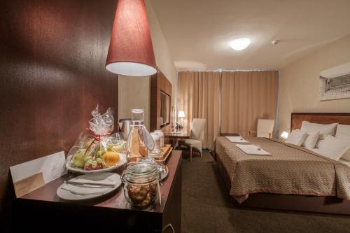 a hotel room with a bed and a tray of fruit on a table at PREMIUM Business Hotel Bratislava in Bratislava
