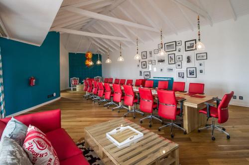 a room with a long table and red chairs at The Delight Swakopmund in Swakopmund