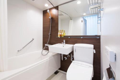 bagno con servizi igienici bianchi e lavandino di HOTEL MYSTAYS Tachikawa a Tachikawa