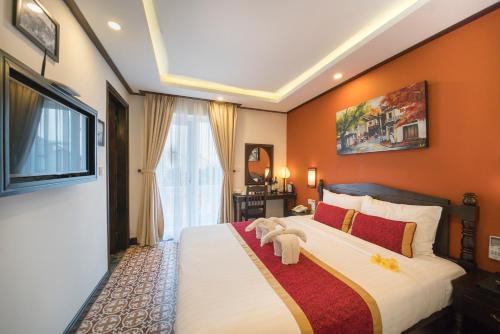 Un dormitorio con una cama con un osito de peluche. en Golden Bell Backpacker Hotel & Pool Bar, en Hoi An