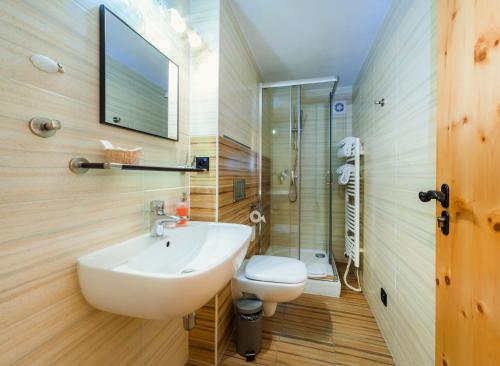 ein Badezimmer mit einem Waschbecken, einem WC und einem Spiegel in der Unterkunft Penzion Ovečka in Nýdek