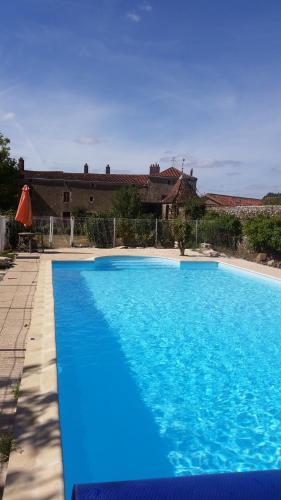 une grande piscine bleue devant un immeuble dans l'établissement Gites De La Brunière, à La Pommeraie-sur-Sèvre