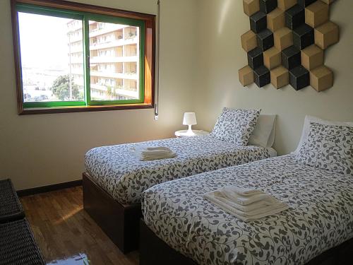 a bedroom with two beds and a window at Porto 1 Bedroom Beach Apartment in Matosinhos