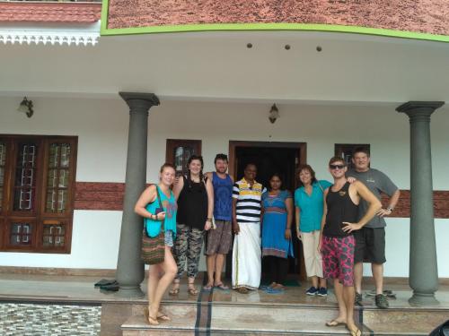 a group of people standing in front of a building at Mango Kerala Homes in Kumarakom