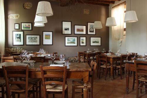 ein Restaurant mit Holztischen und -stühlen und Bildern an der Wand in der Unterkunft Agriturismo Cascina Magana in Burago di Molgora