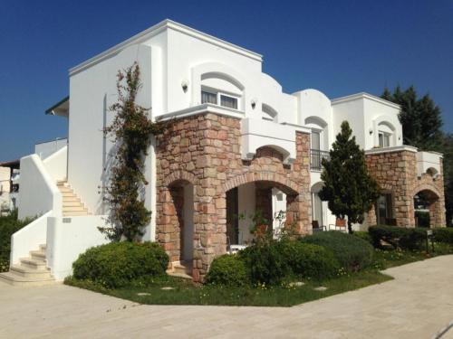 a large white house with a brick at Costa Sariyaz Hotel Bodrum in Bodrum City