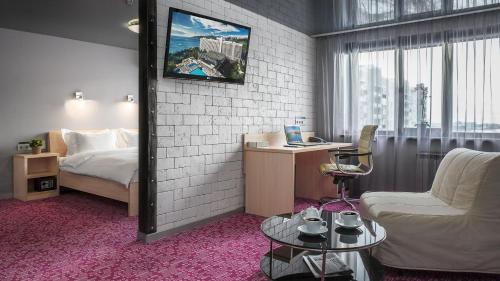 a hotel room with a bed and a tv on the wall at Marins Park Hotel Nizhny Novgorod in Nizhny Novgorod