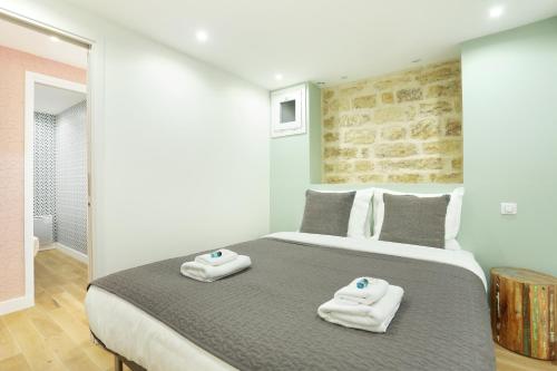 a bedroom with a large bed with towels on it at Rent a Room - Charon 3 in Paris