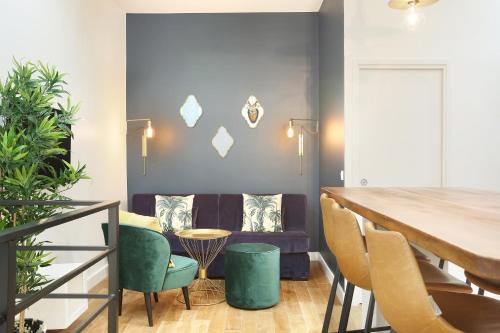 un salon avec un canapé, une table et des chaises dans l'établissement Rent a Room - Charon 3, à Paris