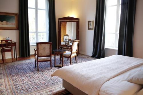 1 dormitorio con 1 cama, 2 sillas y escritorio en Château de Penfrat, en Gouesnach
