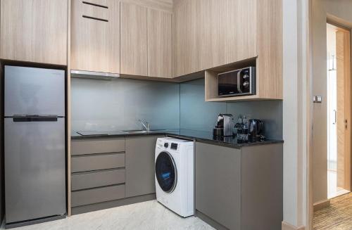 a kitchen with a washing machine and a refrigerator at SKYVIEW Hotel Bangkok - Sukhumvit in Bangkok