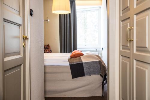 a small bedroom with a bed and a window at Hotell Fjällgården Ski-In Ski-Out in Åre