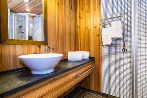a bathroom with a white sink and a shower at Hotell Fjällgården Ski-In Ski-Out in Åre