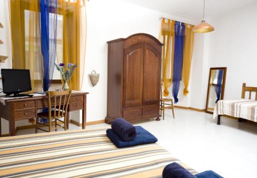 a bedroom with a bed and a desk with a computer at Domo Silvia E Paolo in Nuoro