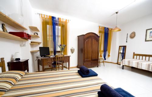 a bedroom with a bed and a desk with a computer at Domo Silvia E Paolo in Nuoro