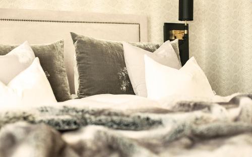a bed with white sheets and pillows at Continental du Sud in Ystad