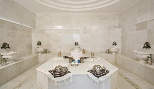 Habitación blanca con mesa y 2 lavabos en Jura Hotels Afyon Thermal, en Afyon
