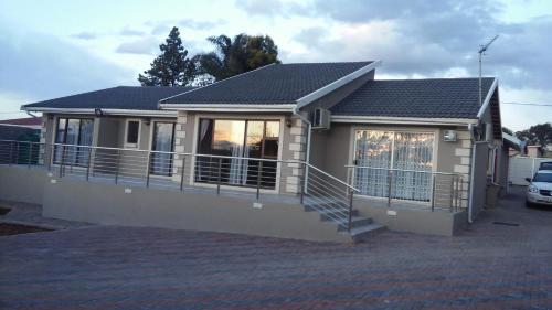 ein kleines Haus mit einer Veranda und einem Balkon in der Unterkunft Lucolo Palace B&B - Mthatha in Mthatha