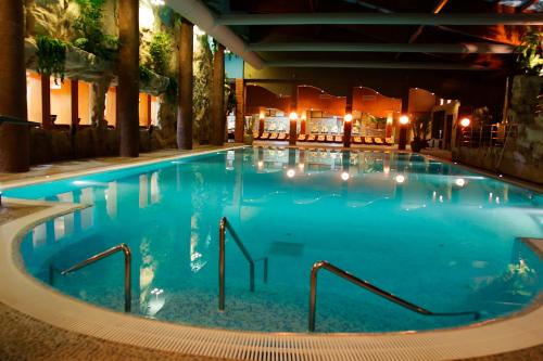 a large swimming pool in a hotel at night at Hotel Imperial Inn in Târgu-Mureş