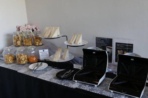 a table with sandwiches and other food items on it at Hotel Chuan Chom The High Resort Saraburi - SHA Plus in Sara Buri