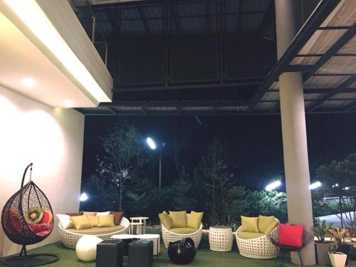 a group of chairs and tables in a patio at night at Hotel Chuan Chom The High Resort Saraburi - SHA Plus in Sara Buri
