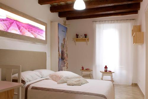 a small bedroom with a bed and a window at Appartamento Alla Corte dei Misteri in Trapani