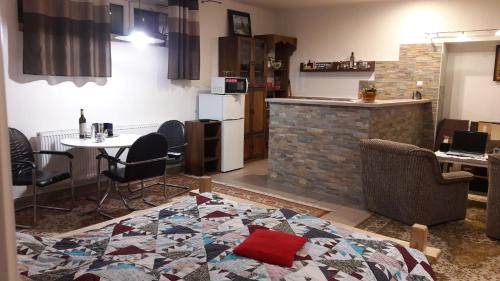 - un salon avec une cuisine et une table avec des chaises dans l'établissement Apartman YVET, à Sučany