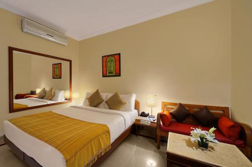 Habitación de hotel con cama y espejo en Casa De Goa - Boutique Resort - Calangute en Calangute