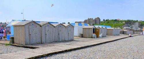 a row of wooden huts on the side of a beach at LE KALEHO, Grand Duplex au coeur de Dieppe - NETFLIX in Dieppe