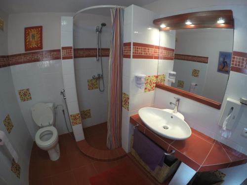 La salle de bains est pourvue de toilettes, d'un lavabo et d'une douche. dans l'établissement Le Dakan, à Saly Portudal