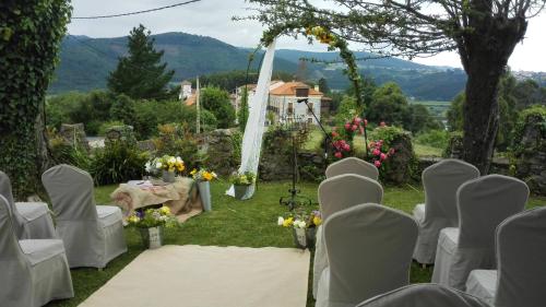 an outdoor wedding with white chairs and a table at Hotel Palacio de la Magdalena in Soto del Barco