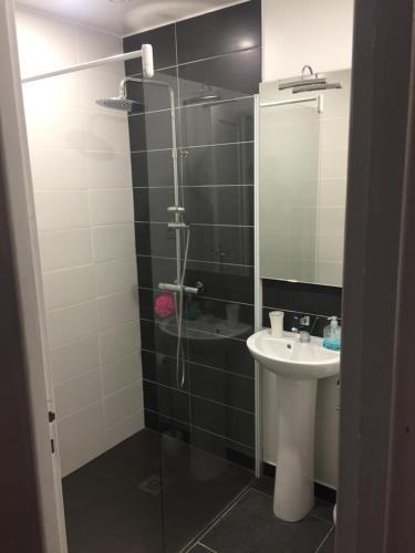 Un baño con ducha, lavabo y espejo. en Maison les Ramparts, en Villefranche-de-Conflent