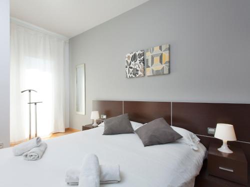 a bedroom with a large bed with white sheets at RentBCN Rambla Catalunya Apartment in Barcelona