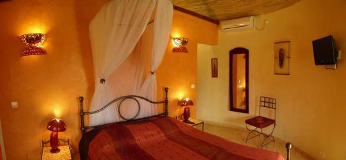 a bedroom with a wooden bed in a room at Le Dakan in Saly Portudal