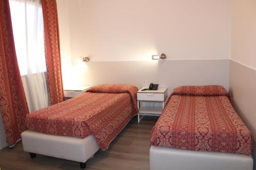 a hotel room with two beds and a mirror at Alla Bianca Hotel in Marghera