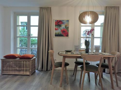 a dining room with a table and chairs and windows at Apartment Potsdam in Potsdam