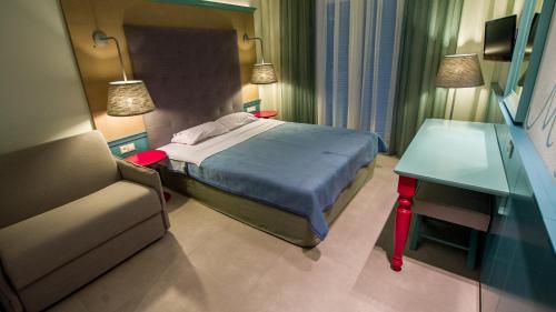- une chambre avec un lit, un bureau et un canapé dans l'établissement Alkyon Hotel, à Patitiri