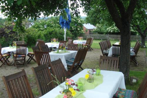a group of tables and chairs with flowers on them at Traditionsgasthof Zum Luedertal in Bimbach
