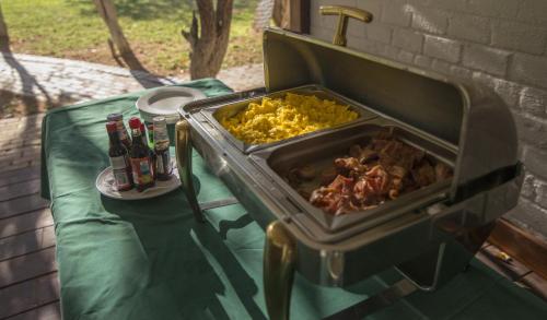 Una mesa con una parrilla con comida y bebidas encima. en Gondwana Damara Mopane Lodge, en Mopane Pos