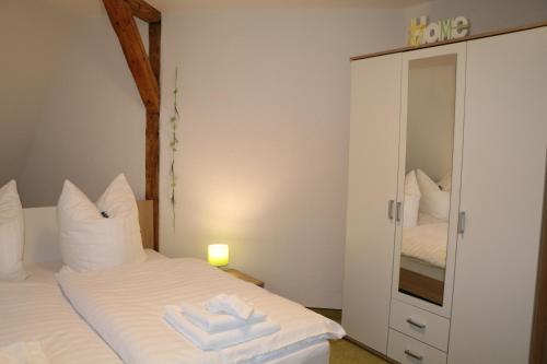 1 dormitorio con cama blanca y espejo en Fewo Friedrichsruh en Bad Elster