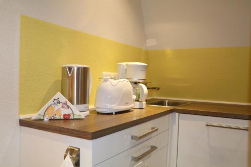 a kitchen with yellow walls and a counter with a appliance at Fewo Friedrichsruh in Bad Elster