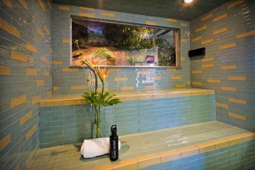 a blue tiled shower with a vase and a window at Crest Hotel in Prince Rupert