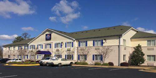 a hotel with cars parked in a parking lot at InTown Suites Extended Stay Tuscaloosa, AL in Tuscaloosa