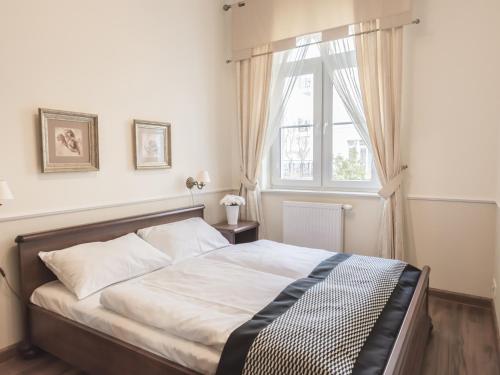 a bedroom with a large bed with a window at VacationClub - Trzy Korony Wazow Apartment 12 in Świnoujście