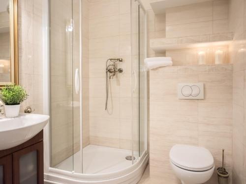 a bathroom with a shower and a toilet and a sink at VacationClub - Trzy Korony Wazow Apartment 12 in Świnoujście