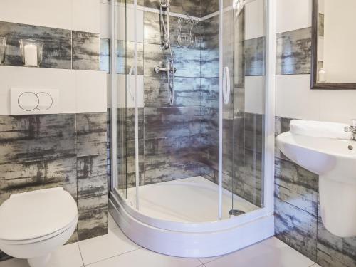 Un baño con ducha, inodoro y lavabo. en VacationClub - Trzy Korony Wazów Apartment 11, en Świnoujście