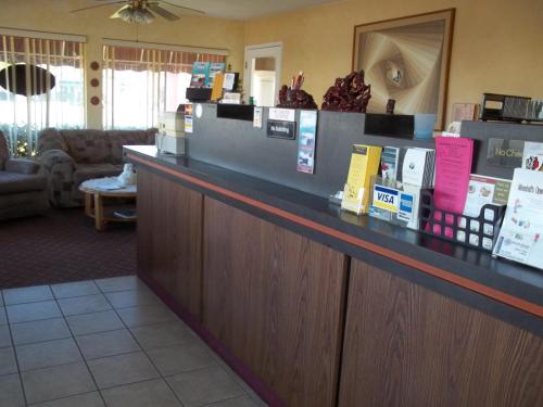 Caja en una habitación de hotel con sofá en Hacienda Motel en Yuma