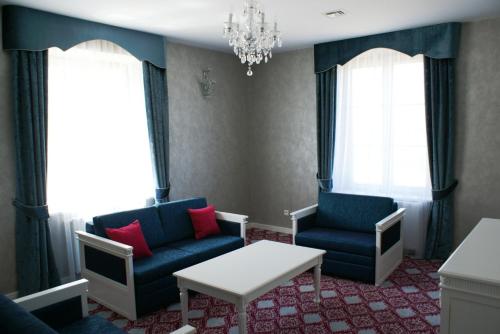 a living room with two chairs and a table at Pałac Domaniowski in Wieniawa